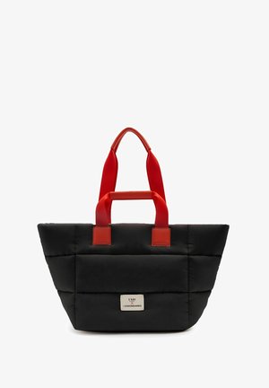 Schwarze gesteppte Tragetasche mit roten Griffen und einem weißen Etikett mit der Aufschrift „UNIO X VISIONNAIRES“ in der Mitte vorne.