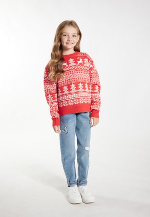 Maglione rosso lavorato a maglia con motivi a tema natalizio bianchi, abbinato a jeans strappati blu chiaro e sneaker bianche.