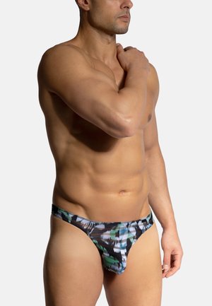 Patterned thong featuring a blend of green, black, and white colors. Made from smooth fabric with a fitted design and minimal coverage.
