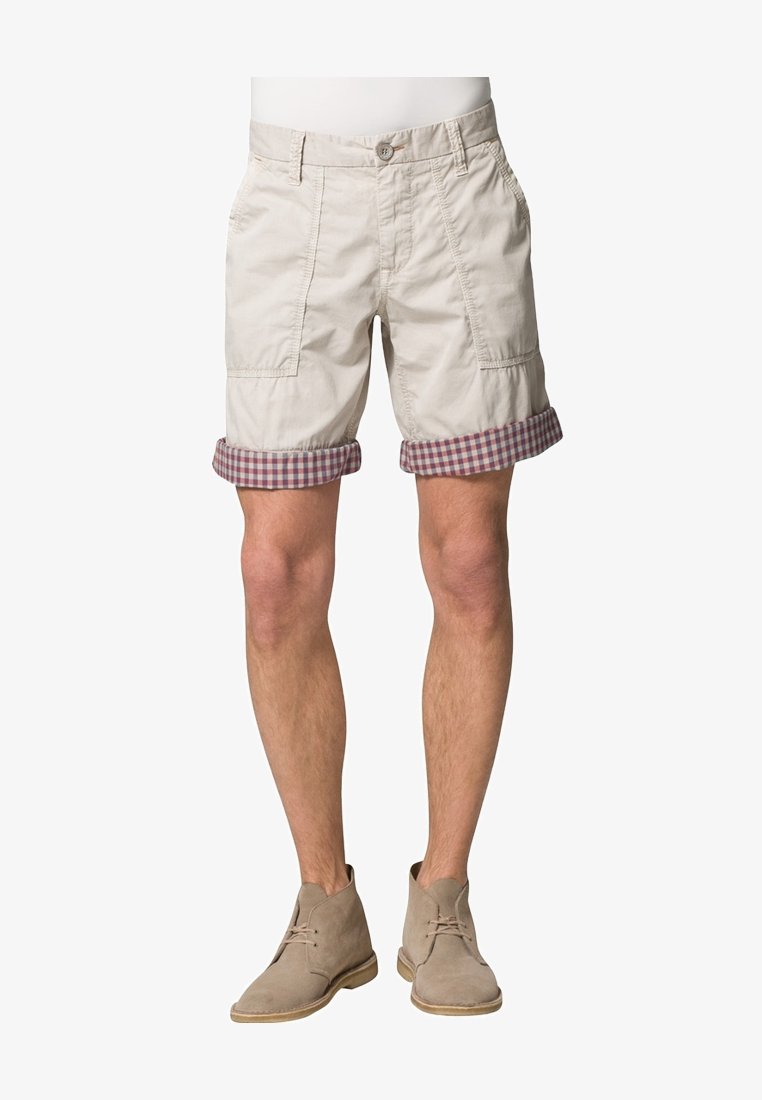 Shorts beiges en coton, avec un ourlet replié à carreaux en bordeaux et crème, des poches latérales et une fermeture à boutons.