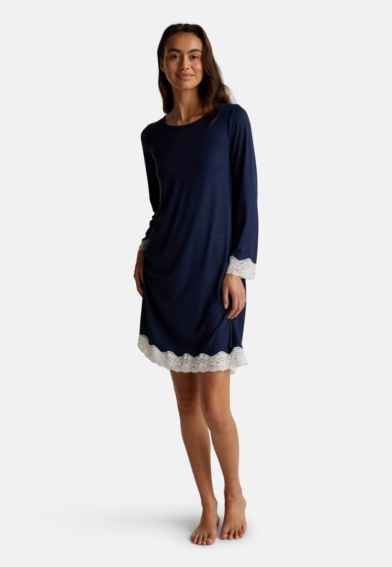 Camicia da notte blu navy con maniche lunghe, caratterizzata da bordi in pizzo bianco sull'orlo e sui polsini. Materiale morbido, vestibilità rilassata, design alla lunghezza del ginocchio.
