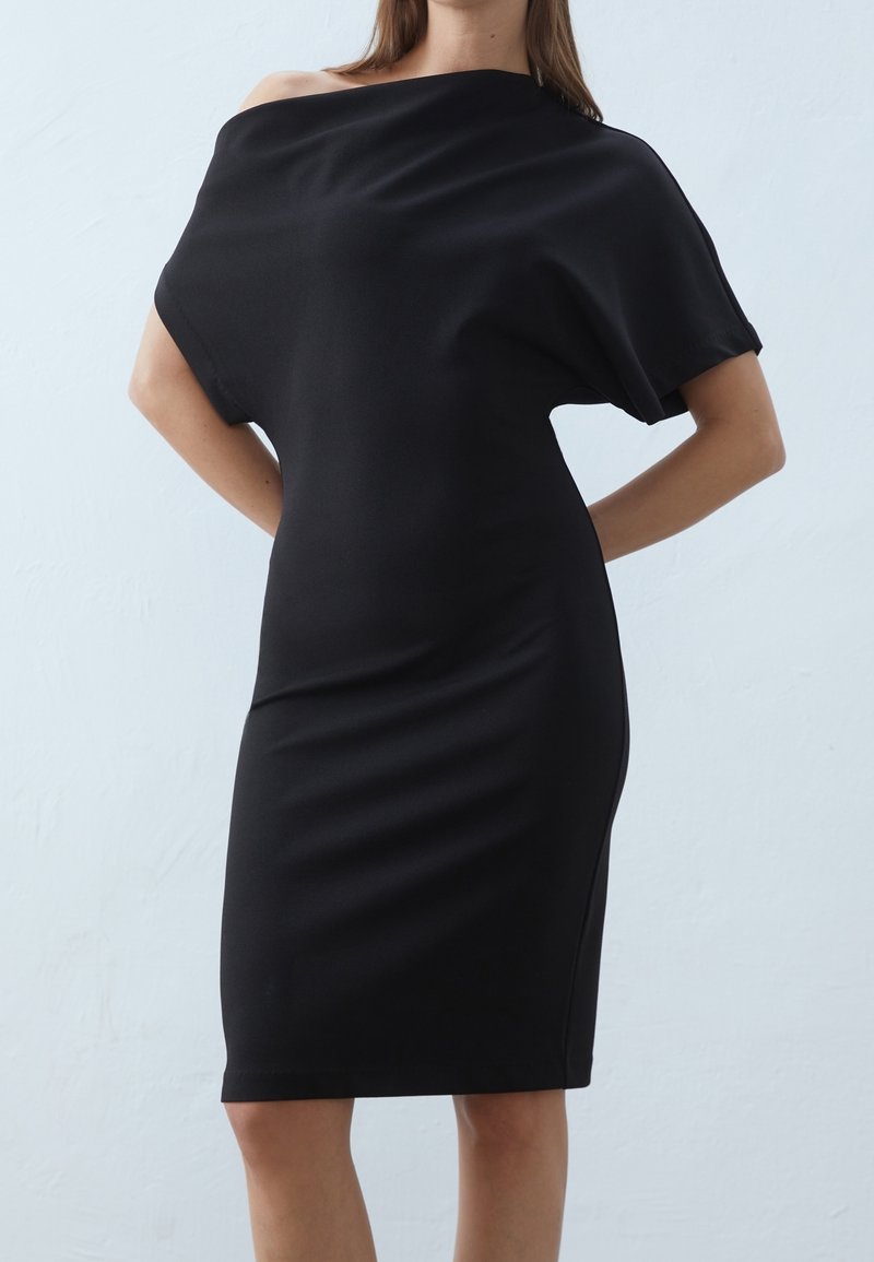 Zwarte off-shoulder jurk met een aansluitende silhouet, korte mouwen en een gladde textuur. Ontworpen voor een strakke, moderne uitstraling.