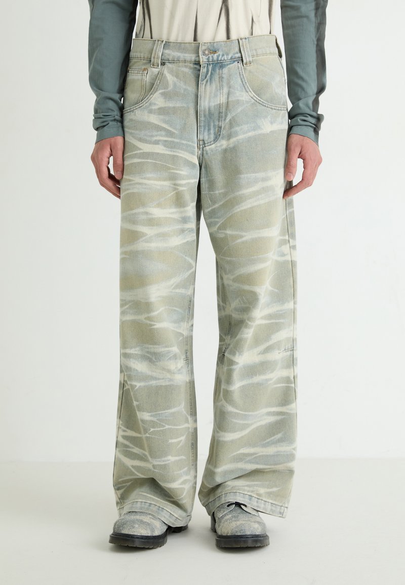 Lys grønn denim vide bukser med en bølgete hvit mønster, fem-lomme design og knappelukking i livet.