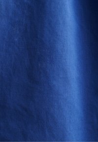 Tessuto blu profondo con una superficie liscia, che mostra sottili variazioni di tonalità e un motivo di tessitura semplice.