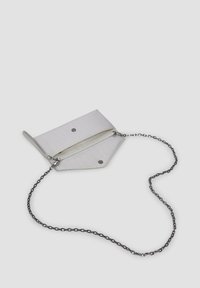 Biała torebka typu crossbody z łańcuszkiem, o trójkątnym kształcie i zamknięciu na zamek, posiadająca dwie wewnętrzne przegrody oraz zatrzaski.