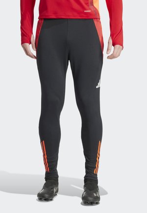 Zwarte sportbroeken met oranje strepen aan de zijkanten. Gemaakt van rekbaar materiaal, ze hebben een slim fit en logo-detail aan de voorkant.