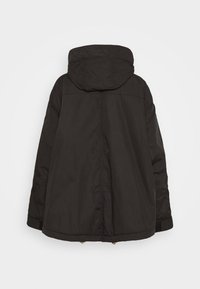 Czarna ocieplana kurtka z kapturem, z pikowanym wzorem na kapturze oraz luźnym krojem i ściągaczem u dołu kurtki.