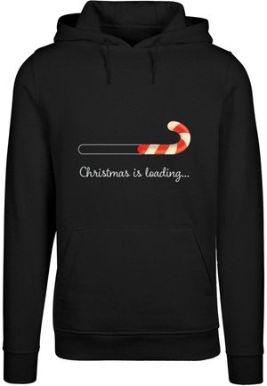 Svart hettegenser med et grafisk bilde av en godteri-stang og teksten "Jula laster..." Materialet er mykt; designet inkluderer en fremre lomme og hette med snor.