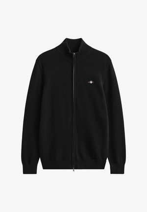 Maglione nero con cerniera realizzato in tessuto lavorato a maglia. Presenta un colletto alto e polsini e orlo a coste. Piccolo logo ricamato sul petto sinistro.