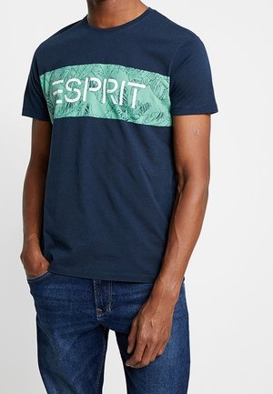 Navyblauwe T-shirt van katoen met een groene gestreepte borstband waarop de tekst "ESPRIT" in het wit staat, ronde halslijn, korte mouwen.
