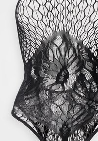 Μαύρο κορμάκι με περίτεχνα δαντελένια σχέδια και σχέδιο δίχτυ ψαριού, που αναδεικνύει ανθικά μοτίβα και ημιδιαφανείς υφές.