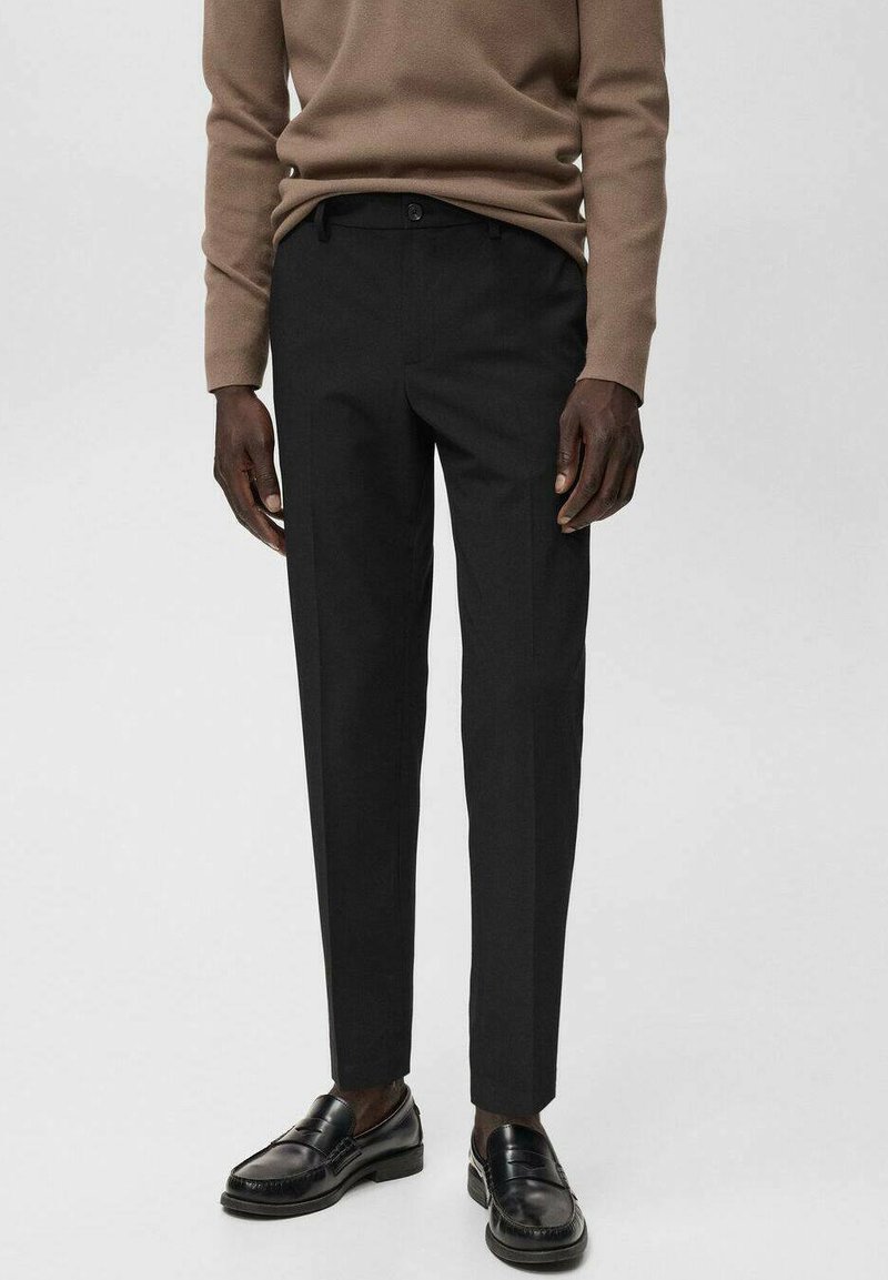 Pantalones negros ajustados con un corte recto, hechos de una tela suave. Cuentan con una cinturilla estándar, trabillas para cinturón y bolsillos laterales.