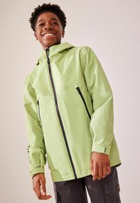 Hellgrüne wasserdichte Jacke mit Kapuze, durchgehendem Reißverschluss und schwarzen Reißverschlussakzenten; verfügt über zwei Reißverschlusstaschen und elastische Bündchen.