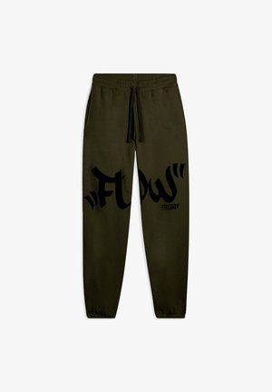 Pantalones de chándal verdes con cintura elástica y cordón negro, que presentan un gran gráfico negro con "FLOW" y "FREDDY" impresos en el lado.