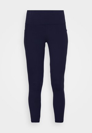 Leggings bleumarin din material elastic, cu o talie înaltă, textură netedă și buzunare laterale pe șolduri.