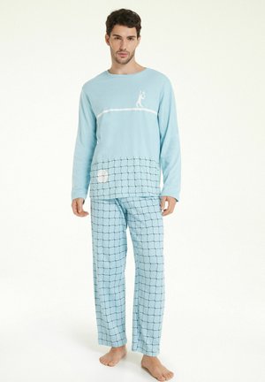 Helles blaues Pyjama-Set mit langärmeligem Oberteil, das eine weiße Linzeichnungsdarstellung zeigt, und karierten Hosen mit schwarz-weißem Gittermuster. Weicher Stoff, entspannter Schnitt.