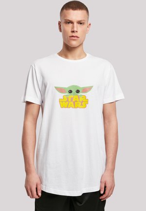 White cotton t-shirt featuring a graphic of a green character with large eyes and pink ears, accompanied by the yellow "STAR WARS" text below.