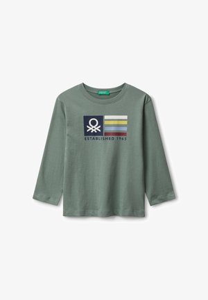 Camisa de manga larga verde con un logo y rayas de colores sobre el texto "Establecido en 1965" en el centro del frente.
