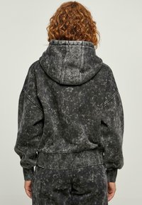 Felpa con cappuccio tie-dye in bianco e grigio, dalla vestibilità oversize, con polsini e orlo a costine, e una finitura in tessuto morbido e texturizzato.