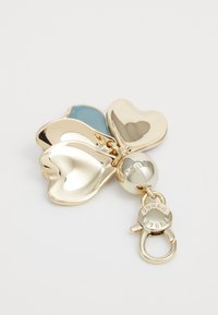 Charm en métal doré présentant trois éléments en forme de cœur de couleurs variées, avec une finition brillante et un fermoir amovible.