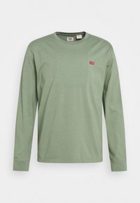 Langärmliges T-Shirt aus weichem, hellgrünem Baumwollstoff mit rundem Halsausschnitt. Mit kleinem roten Levi's-Logo auf der Brust.