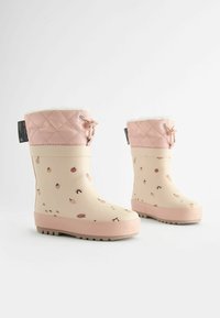 Bottes de pluie en caoutchouc avec un corps beige clair, un revers matelassé rose et une doublure en fausse fourrure blanche ; décorées de motifs colorés de fruits et d'arc-en-ciel.