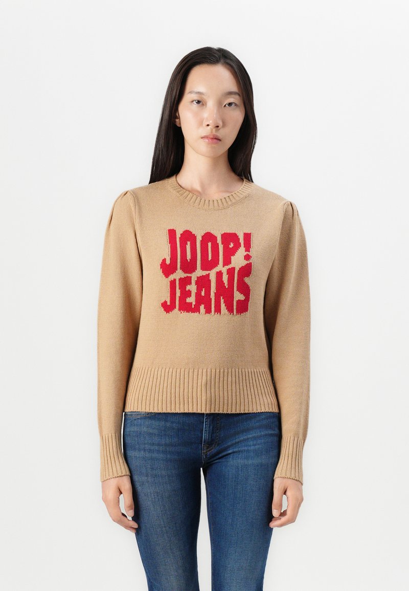 Beige gebreide trui met het rode "JOOP! JEANS" logo. Ribgebreide mouwen en zoom, ronde halslijn en een zachte textuur. Slim fit.