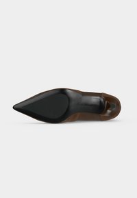 Escarpin à talon haut marron à bout pointu vu par le dessous, mettant en valeur la semelle noire et le talon.