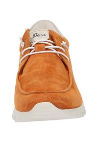 Oranges Wildleder-Schuh mit weißen Schnürsenkeln und einer weißen Gummisohle. Verfügt über eine abgerundete Zehenpartie und eine weiche Textur, mit minimalem Branding auf der Zunge.