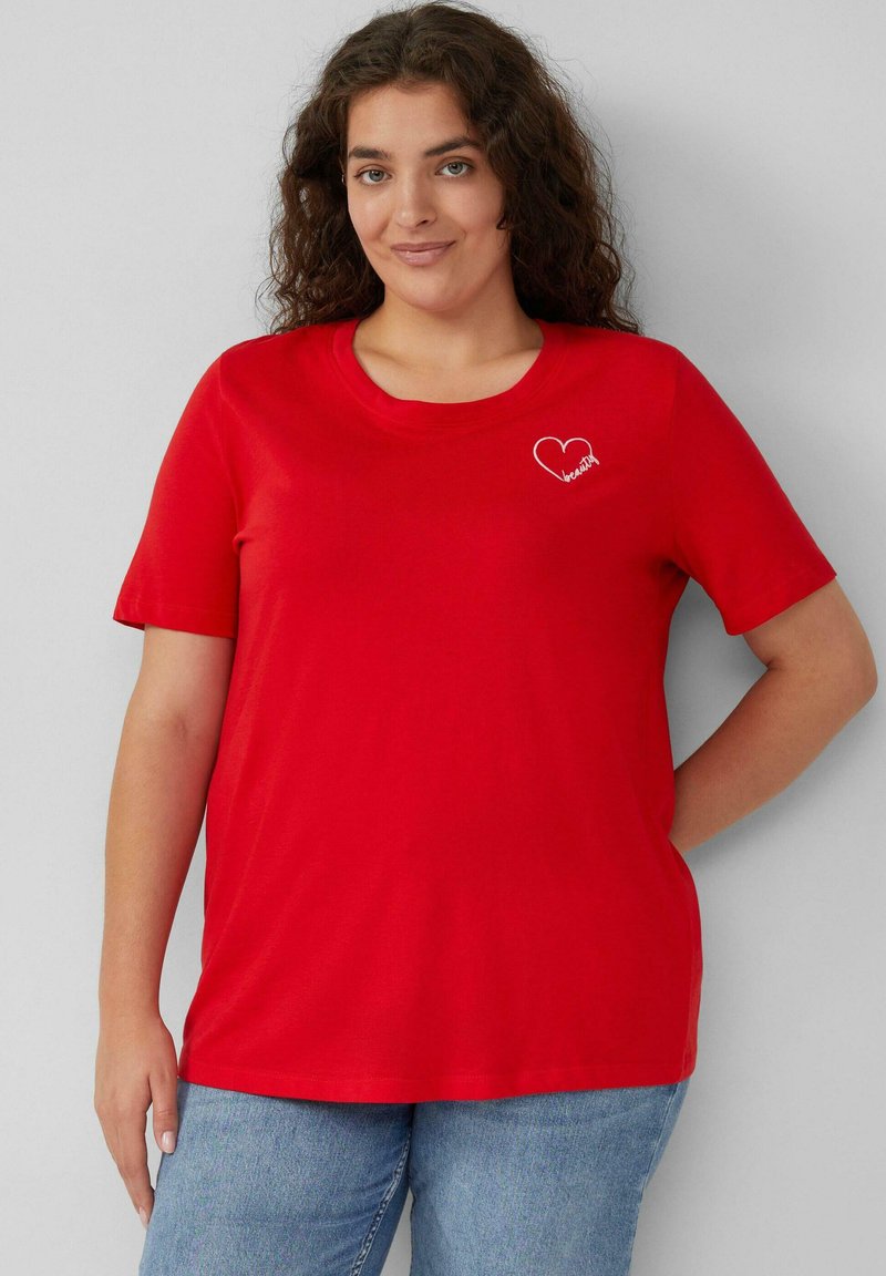 Rotes T-Shirt aus Baumwolle mit kurzen Ärmeln und rundem Ausschnitt. Es hat ein kleines weißes Herz-Graphic mit dem Wort "Schönheit" darin.