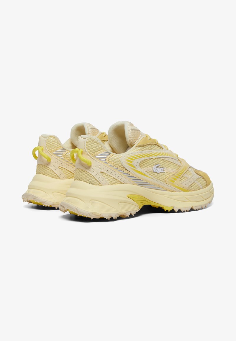 Helle gelbe Sportschuhe mit einem Obermaterial aus Mesh und Synthetik, runder Spitze, strukturiertem Profil und kleinen gelben Akzenten an der Ferse und den Schnürsenkeln.