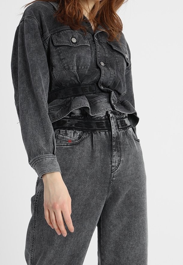 Ciemnoszara kurtka dżinsowa z przednimi kieszeniami, zestawiona z dopasowanymi wysokim stanem spodniami z grubym czarnym paskiem w talii i subtelnymi detalami tekstury.