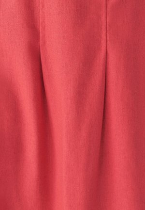 Korallivärviline pleeditud kangas, millel on tekstureeritud pind. Materjal näib olevat tugev ja kerge, ideaalne rõiva või aksessuaari jaoks.