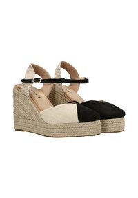 Sandalias de cuña con parte superior de tela beige, puntera negra y media suela de yute trenzado. Presentan una correa negra en el tobillo y materiales texturizados.