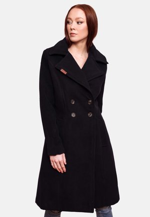 Black double-breasted coat in soft fabric, featuring large lapels, front pockets, and dark buttons. Includes a small brand tag on the collar.