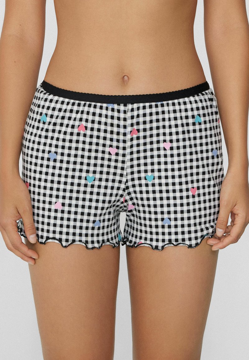 Zwart-witte geruite shorts met een geschulpte zoom, versierd met kleurrijke hartpatronen in roze, blauw en lichtblauw. Elastische tailleband.
