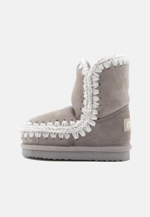 Bota de tornozelo em camurça cinza com bico arredondado, costura branca decorativa ao longo da borda e sola de borracha texturizada.