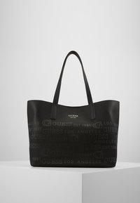 Sort totebag lavet af tekstureret syntetisk materiale, med præget branding og glatte kunstlæder-håndtag. Åben topdesign.