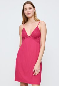Camicia da notte rosa con spalline regolabili, dotata di un bustino in pizzo e di un scollo triangolare, tessuto liscio e vestibilità comoda.