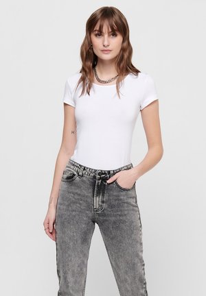 White short-sleeve t-shirt made of cotton, paired with high-waisted gray jeans featuring a faded wash and contrast stitching.