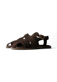Paar dunkelbraune Herrensandalen aus Wildleder mit mehreren Riemen und einer seitlichen Schnalle auf flachen Sohlen vor weißem Hintergrund.