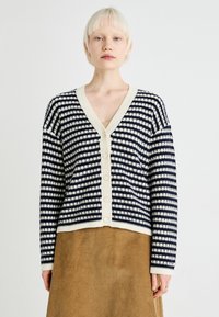 Navy and cream striped cardigan with a V-neck, button front, and long sleeves; textured knit fabric with contrasting ribbed trim.