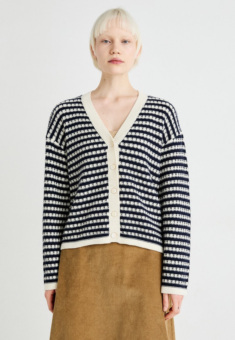 Navy and cream striped cardigan with a V-neck, button front, and long sleeves; textured knit fabric with contrasting ribbed trim.
