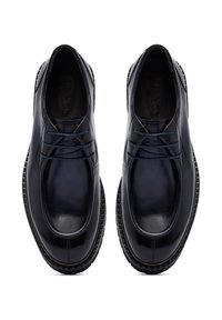 Marine leren schoenen met een gladde afwerking, ronde neus en zes oogjes voor veters. Dikke zwarte rubberen zool met een gestructureerd detail.