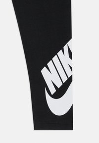 Leggings de algodão pretos com um grande logo branco da Nike e design do swoosh na parte inferior esquerda, com uma textura suave e formato ajustado.