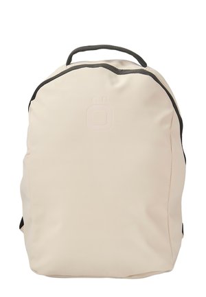 Mochila de color beige claro con una textura suave y mate, forma redondeada, acentos negros en contraste y un logo estampado en la parte delantera.