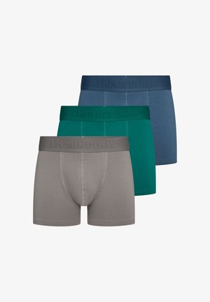 Drie paar herenboxerslips in grijs, groen en blauw, elk met een gebrandmerkte tailleband en zichtbare stiksel details.