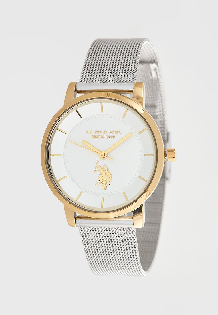 Zilveren gaasarmbandhorloge met een goudkleurige metalen kast. Witte wijzerplaat met gouden wijzers en een polo-spelerlogo. Minimalistisch ontwerp.