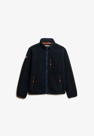 Fleecejakke i mørk navy med fuld lynlås, høj krave og orange detaljer. Har to lukkede brystlommer og tekstureret stof.