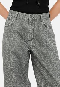 Grijze denim wijde broek met een subtiele luipaardprint en decoratieve studs op de stof. Heeft een klassiek vijf-pocket ontwerp.